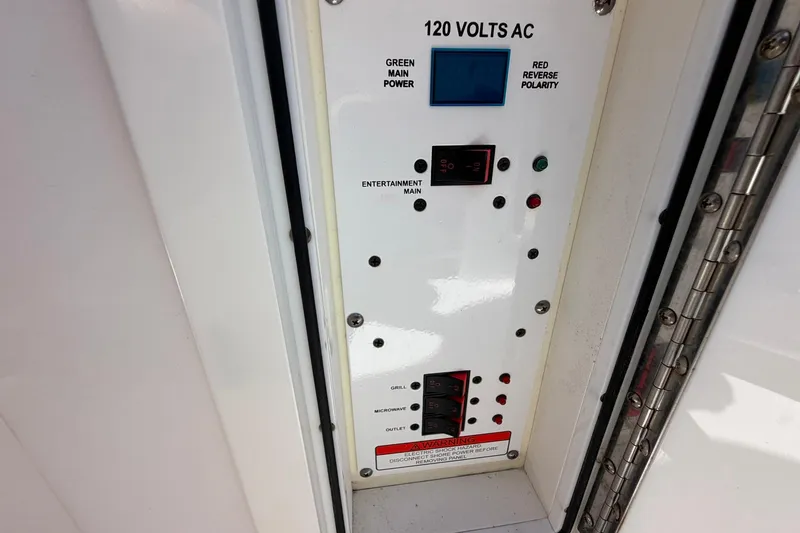 Slide: The Image of Electrical panel of a 2016 Edgewater 368CC boat, showing 120 volts AC controls. - 64