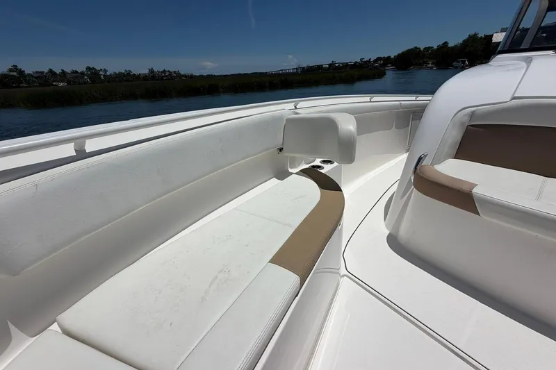 Slide: The Image of 2016 Edgewater 368CC boat interior with white and tan seating, on a sunny day. - 32