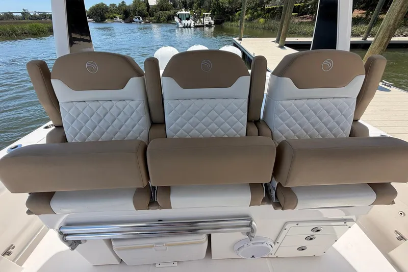 Slide: The Image of 2016 Edgewater 368CC boat seats with quilted design, docked by a serene waterfront. - 37
