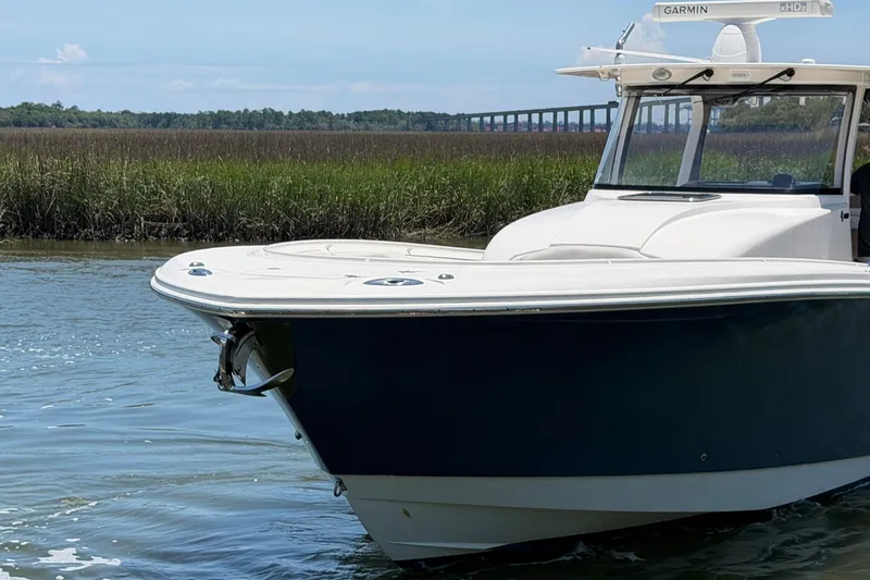 Slide: The Image of 2016 Edgewater 368CC boat on calm water with marshland and bridge in background. - 13