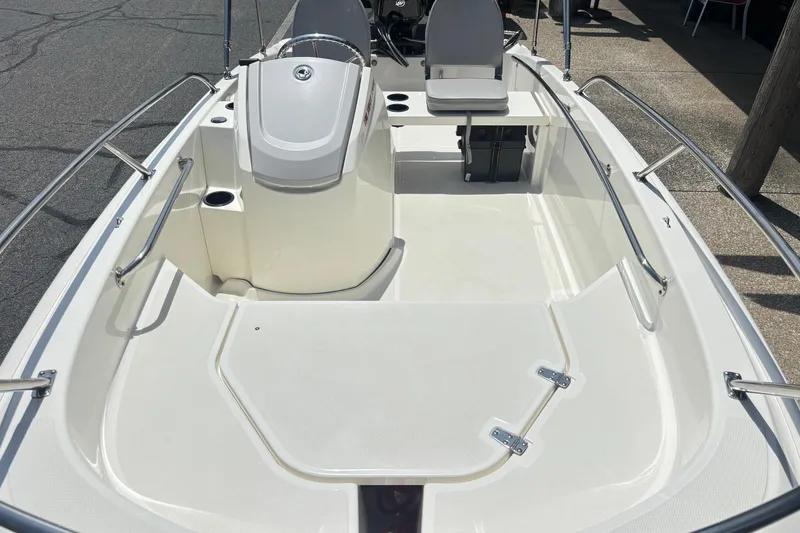 Slide: The Image of 2019 Boston Whaler 130 Super Sport boat interior with seating and steering console. - 10