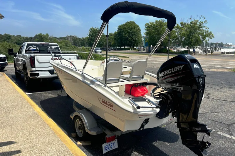 Slide: The Image of 2019 Boston Whaler 130 Super Sport boat with Mercury engine on trailer. - 6