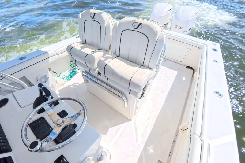 Slide: The Image of 2014 Jupiter 30 FS boat interior with dual seats and steering wheel on open water. - 21