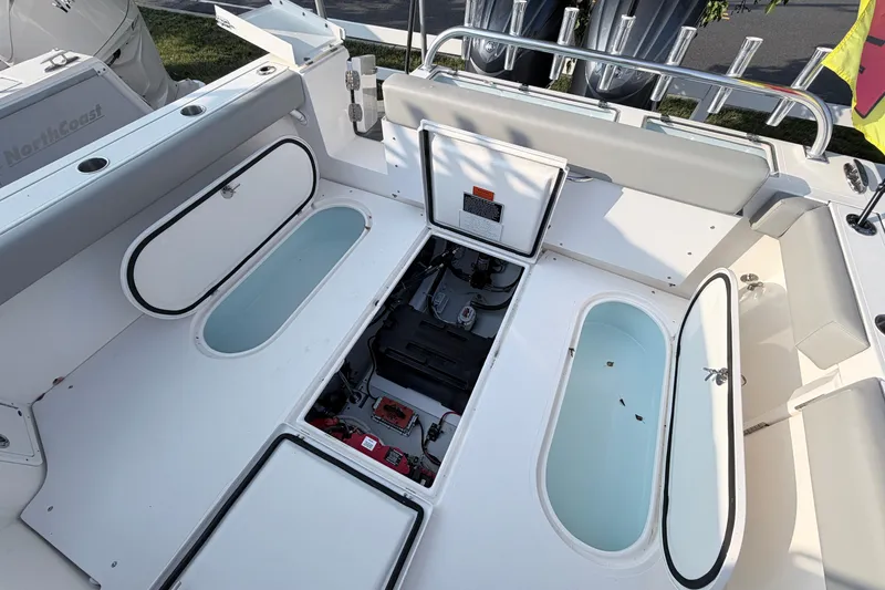 Slide: The Image of 2024 NorthCoast 315 HT boat interior with open storage compartments and seating area. - 10