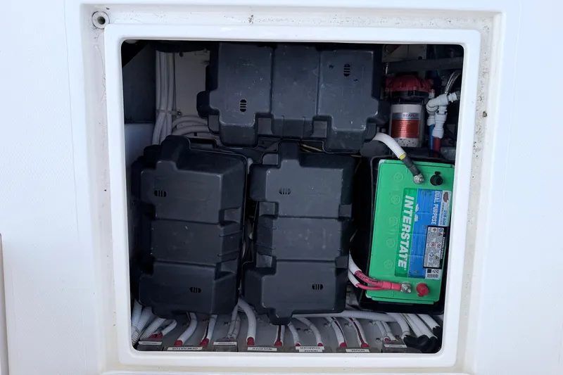 Slide: The Image of Battery compartment of 2024 NorthCoast 315 HT boat, featuring Interstate battery and wiring. - 13
