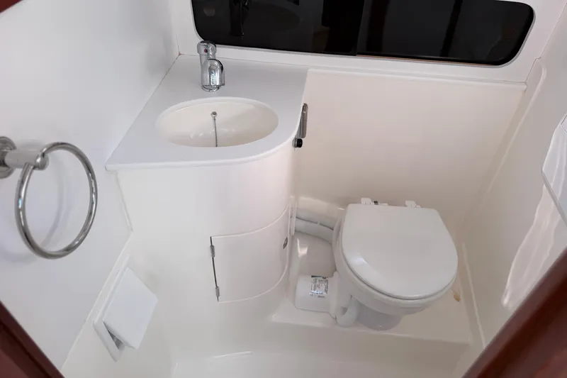 Slide: The Image of 2024 NorthCoast 315 HT boat bathroom with sink, toilet, and towel ring. - 22