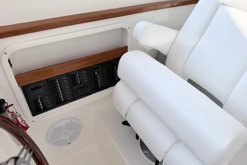 Slide: The Image of 2024 NorthCoast 315 HT boat interior with white seating and control panel. - 17
