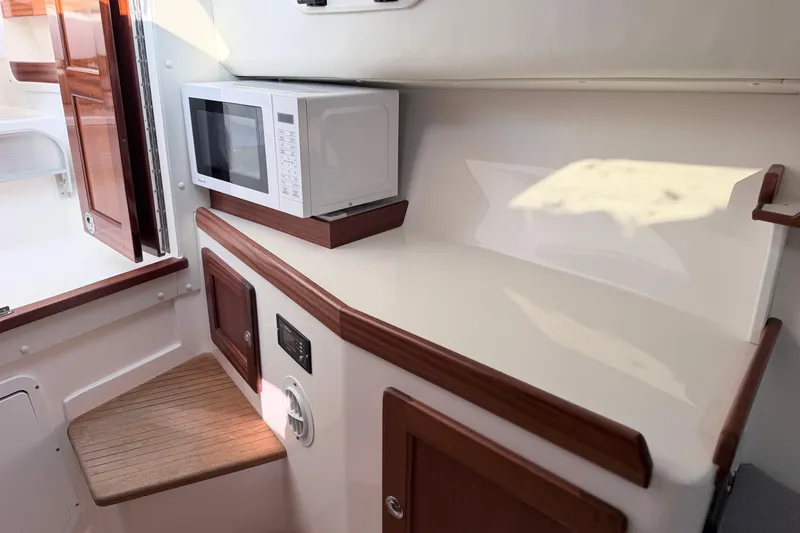 Slide: The Image of 2024 NorthCoast 315 HT interior with microwave and wooden cabinetry. - 21