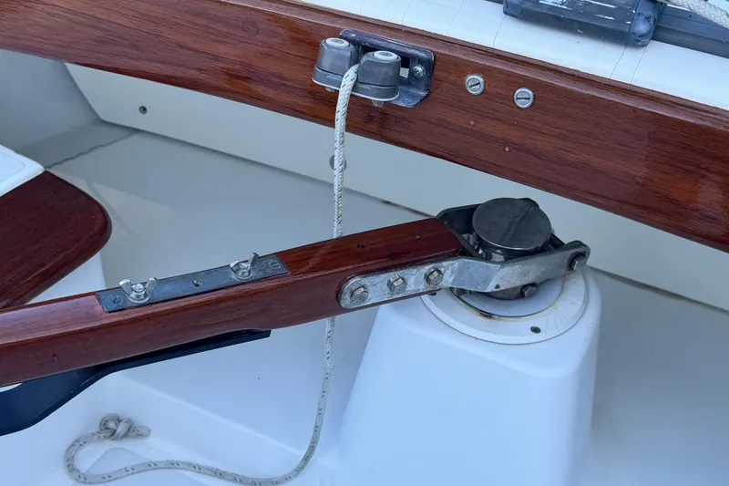 Slide: The Image of Tiller and rudder mechanism of a 1995 Alerion 28 sailboat, featuring polished wood and metal components. - 7