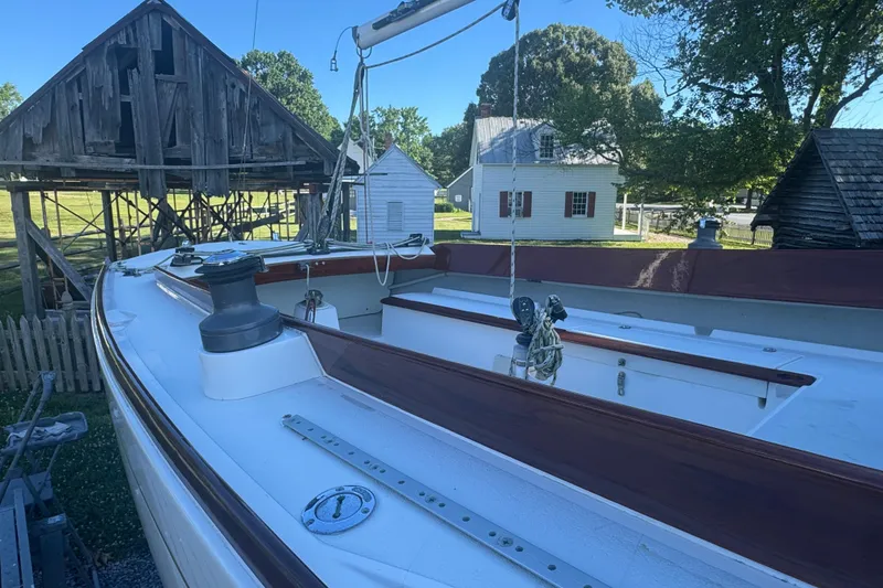 Slide: The Image of Alerion 28 sailboat from 1995, docked near rustic wooden buildings. - 4