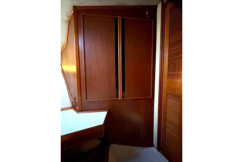Slide: The Image of 1988 Sea Ray 415 Aft Cabin interior with wooden cabinetry and closet. - 48