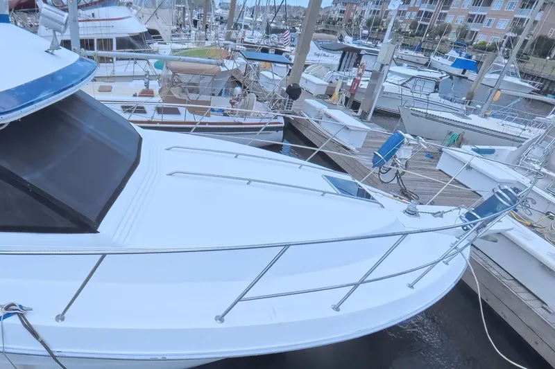 Slide: The Image of 1988 Sea Ray 415 Aft Cabin yacht docked at a marina with other boats. - 7