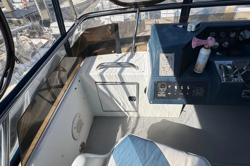 Slide: The Image of 1988 Sea Ray 415 Aft Cabin helm with controls and seating, docked at marina. - 12