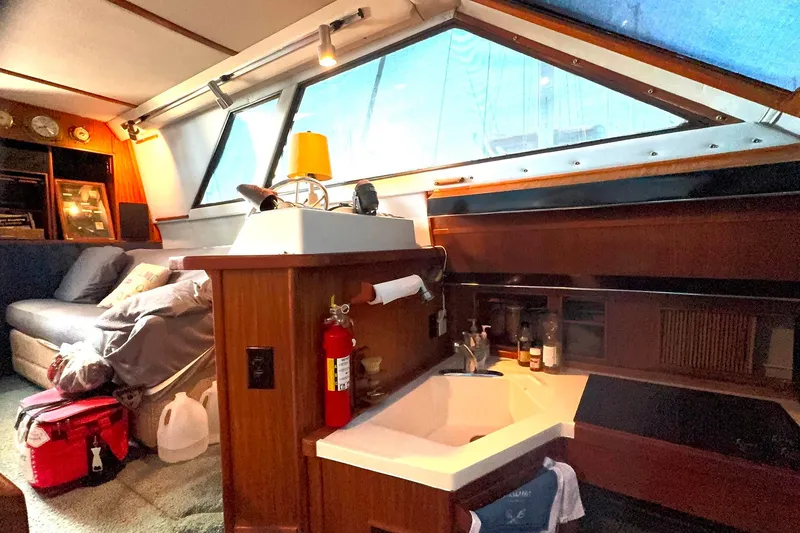Slide: The Image of Interior of 1988 Sea Ray 415 Aft Cabin with cozy seating and kitchenette. - 42