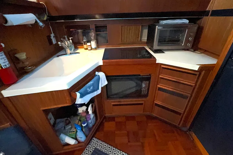 Slide: The Image of 1988 Sea Ray 415 Aft Cabin kitchen with sink, stove, and microwave. - 39