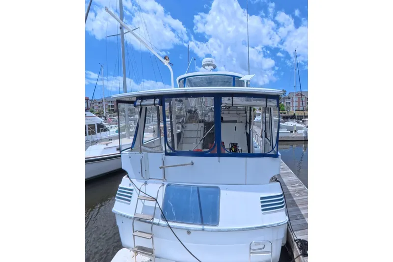 Slide: The Image of 1988 Sea Ray 415 Aft Cabin yacht docked at marina under blue sky. - 3