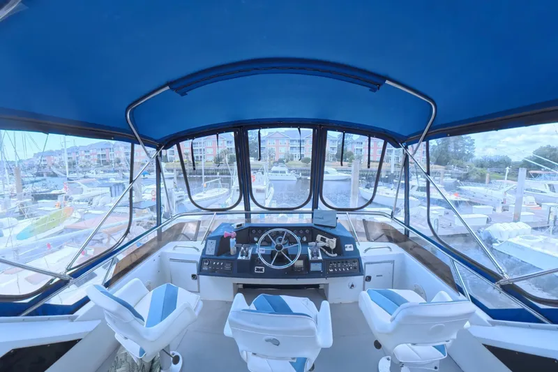 Slide: The Image of Interior view of 1988 Sea Ray 415 Aft Cabin yacht helm with marina backdrop. - 10