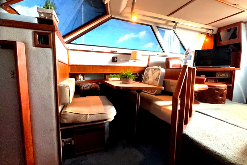 Slide: The Image of Interior of 1988 Sea Ray 415 Aft Cabin with cozy seating and large windows. - 44