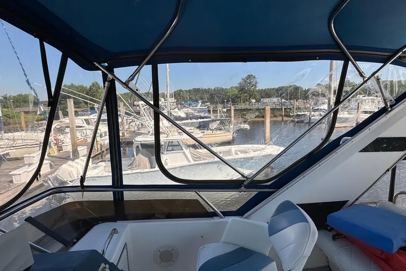 Slide: The Image of 1988 Sea Ray 415 Aft Cabin interior view, overlooking marina with multiple boats docked. - 27