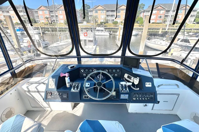 Slide: The Image of Cockpit of 1988 Sea Ray 415 Aft Cabin yacht with marina view. - 11
