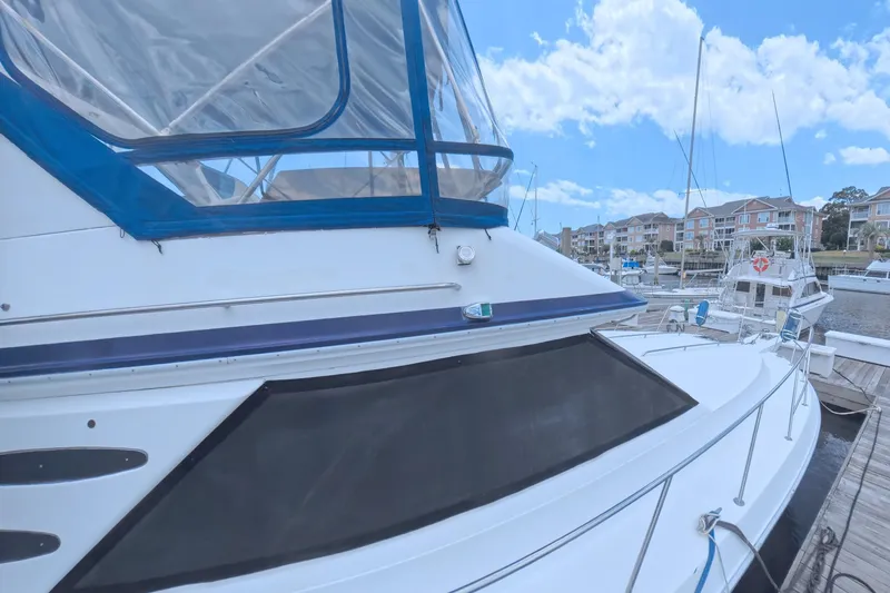 Slide: The Image of 1988 Sea Ray 415 Aft Cabin yacht docked at marina under blue sky. - 8
