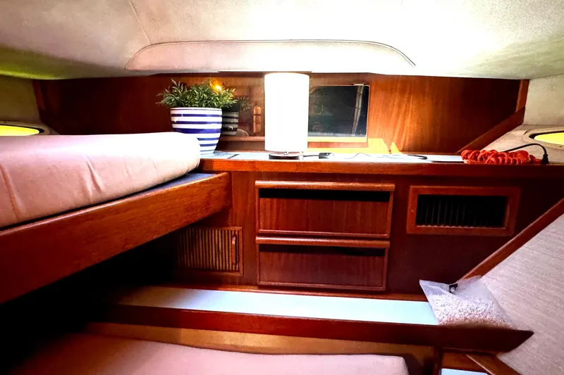 Slide: The Image of 1988 Sea Ray 415 Aft Cabin interior with cozy bed, lamp, and potted plant. - 59