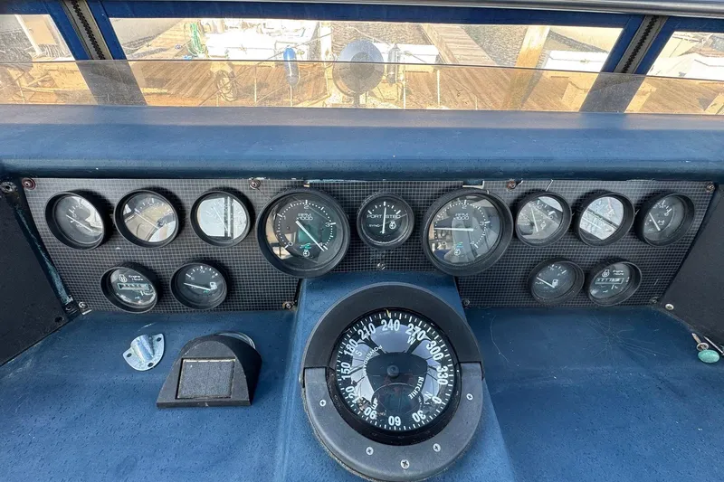 Slide: The Image of 1988 Sea Ray 415 Aft Cabin dashboard with gauges and compass, showcasing nautical instrumentation. - 16