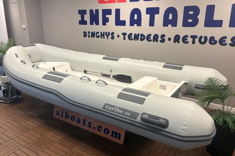 Slide: The Image of Inflatable Caribe C-14 boat, 2026 model, displayed indoors with promotional signage. - 4