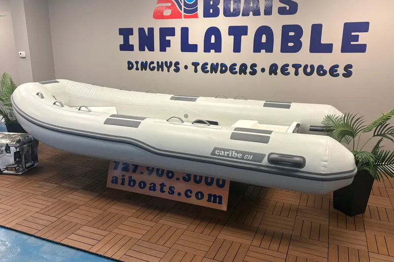 Slide: The Image of Inflatable Caribe C-14 boat displayed indoors, 2026 model, with promotional signage. - 3