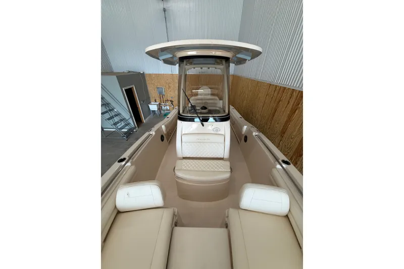 Slide: The Image of 2025 Grady-White Fisherman 216 boat interior with seating and helm in a storage facility. - 15