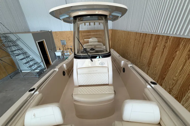 Slide: The Image of 2025 Grady-White Fisherman 216 boat in indoor storage, showcasing sleek design and seating. - 14