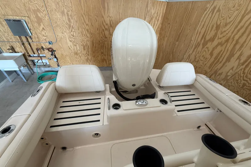 Slide: The Image of 2025 Grady-White Fisherman 216 boat interior with engine and seating in a wooden garage. - 16