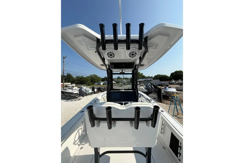 Slide: The Image of 2026 Tidewater 256 CC Adventure boat with rod holders and T-top in a marina setting. - 4