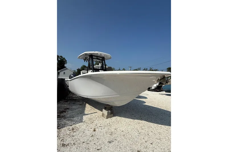 Slide: The Image of 2026 Tidewater 256 CC Adventure boat on display under clear blue sky. - 2
