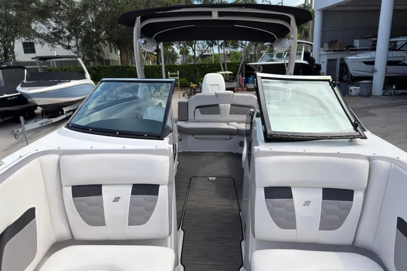 Slide: The Image of 2018 Four Winns HD270 OB boat interior with white seating and open windshield. - 15