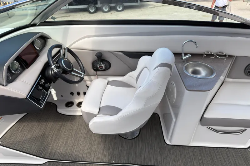 Slide: The Image of 2018 Four Winns HD270 OB boat interior with steering wheel, dashboard, and sink. - 7