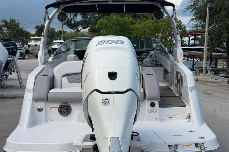 Slide: The Image of 2018 Four Winns HD270 OB boat with powerful outboard motor, docked in a marina setting. - 17