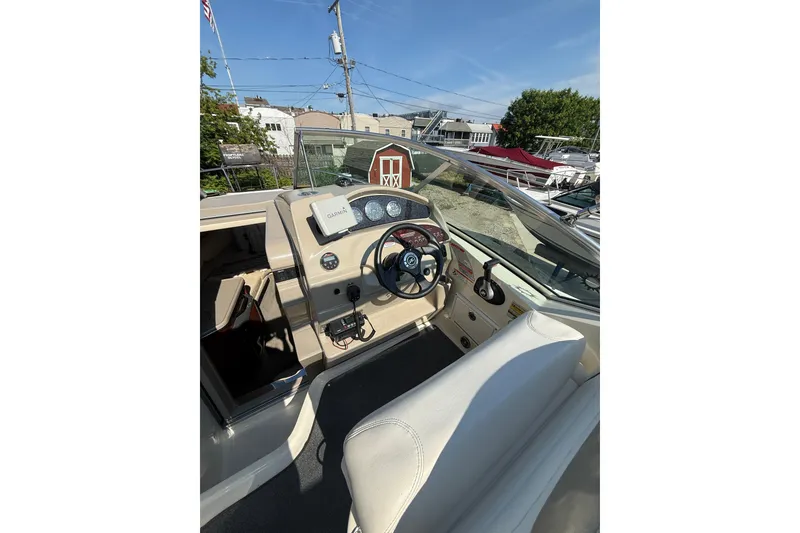 Slide: The Image of 2006 Sea Ray 240 Sundancer boat cockpit with steering wheel and dashboard controls. - 8
