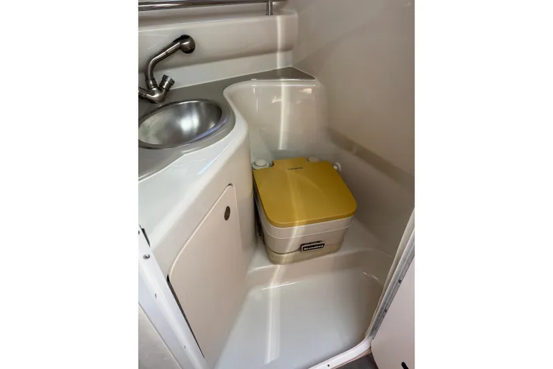 Slide: The Image of Compact bathroom in 2006 Sea Ray 240 Sundancer boat with sink and portable toilet. - 11