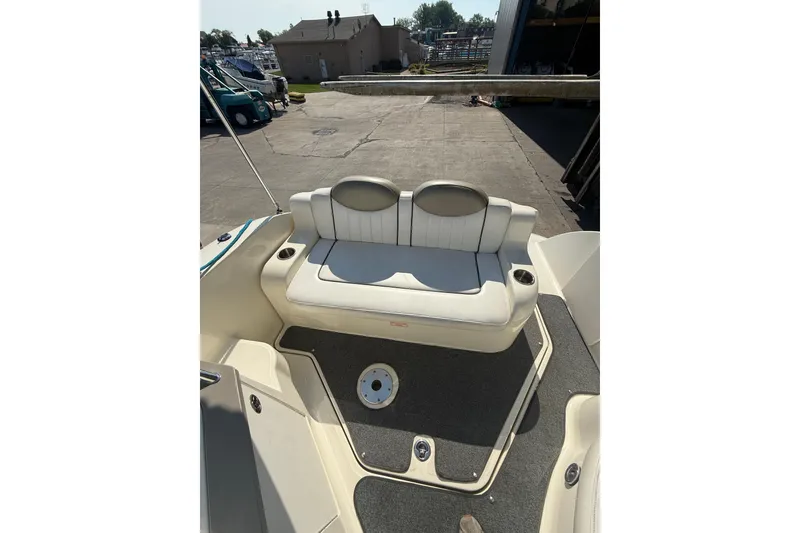 Slide: The Image of 2006 Sea Ray 240 Sundancer boat interior with cushioned seating and cup holders. - 7