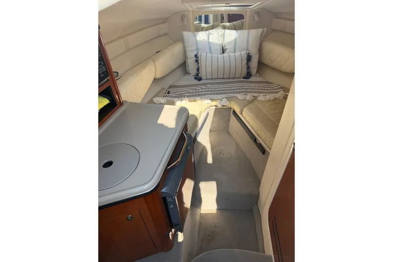 Slide: The Image of Interior of 2006 Sea Ray 240 Sundancer boat with cozy seating and compact kitchenette. - 10