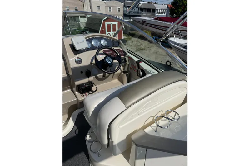Slide: The Image of 2006 Sea Ray 240 Sundancer helm with Garmin GPS, steering wheel, and cup holders. - 21
