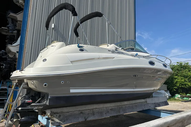Slide: The Image of 2006 Sea Ray 240 Sundancer boat on a lift, ready for maintenance or storage. - 23