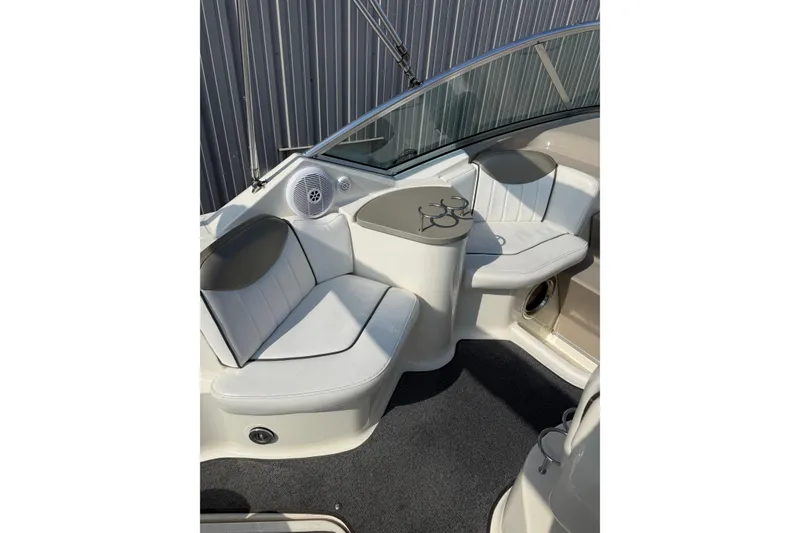 Slide: The Image of 2006 Sea Ray 240 Sundancer boat interior with white seating and cup holders. - 19
