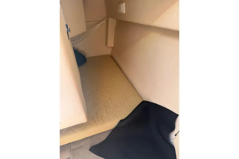 Slide: The Image of Interior cabin of 2006 Sea Ray 240 Sundancer with beige upholstery and sleeping area. - 12