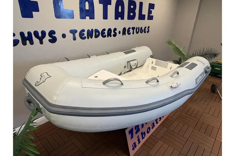 Slide: The Image of Inflatable Caribe C-9X boat, 2026 model, displayed indoors with promotional signage. - 5