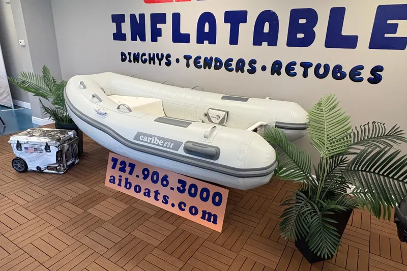 Slide: The Image of Inflatable Caribe C-9X boat display with contact information and decorative plants. - 3