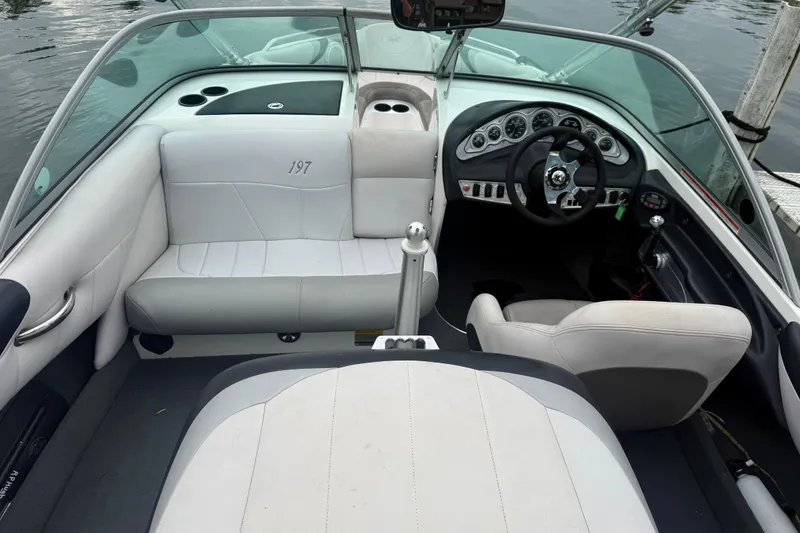 Slide: The Image of 2005 MasterCraft ProStar 197 boat interior with white seating and sleek dashboard design. - 12