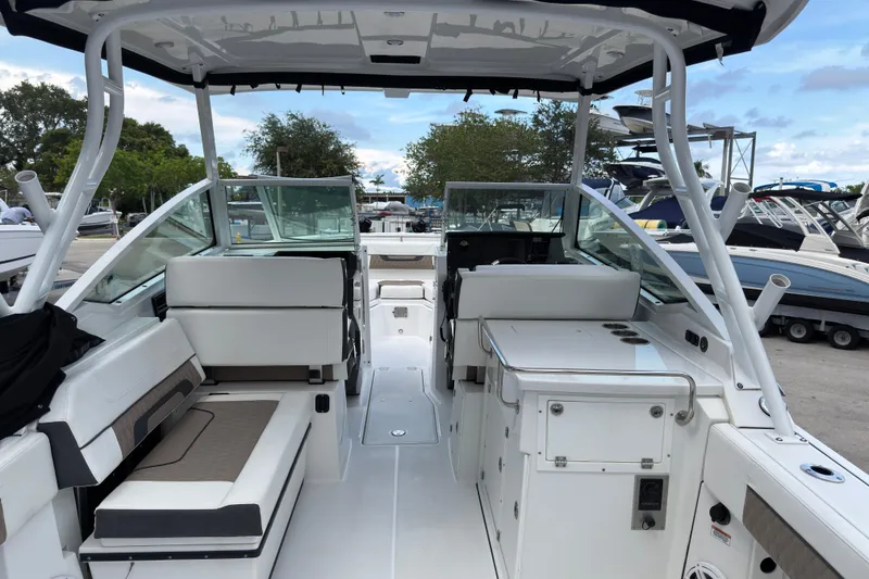 Slide: The Image of 2023 Blackfin 272 DC boat interior with seating and storage, docked at a marina. - 3