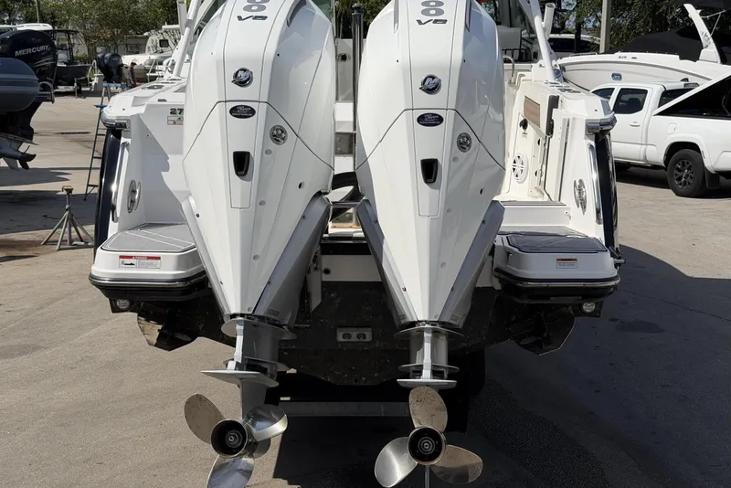 Slide: The Image of 2023 Blackfin 272 DC boat with dual outboard engines, displayed at a marina. - 23
